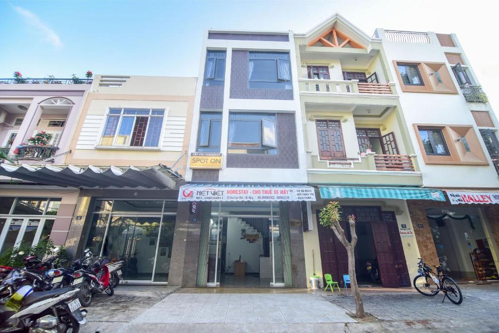 Mặt tiền Nét Việt Homestay bốn tầng, cửa kính rộng, biển hiệu trắng đỏ và nhiều xe máy đỗ bên trái